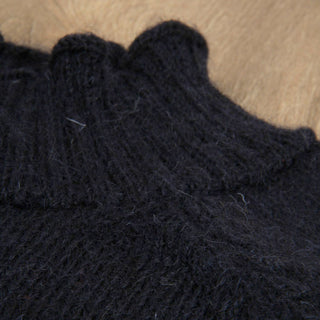 Close-up of dark blue knitted jumper showing the neck detail