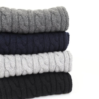 stack of cable scarves on a white background