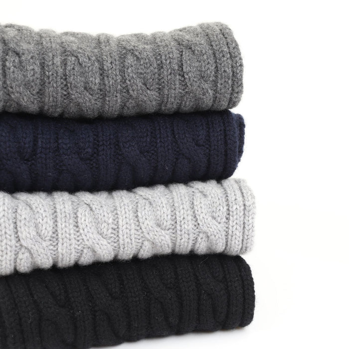 stack of cable scarves on a white background