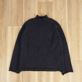 flat image of a navy roll neck pullover on a wooden floor