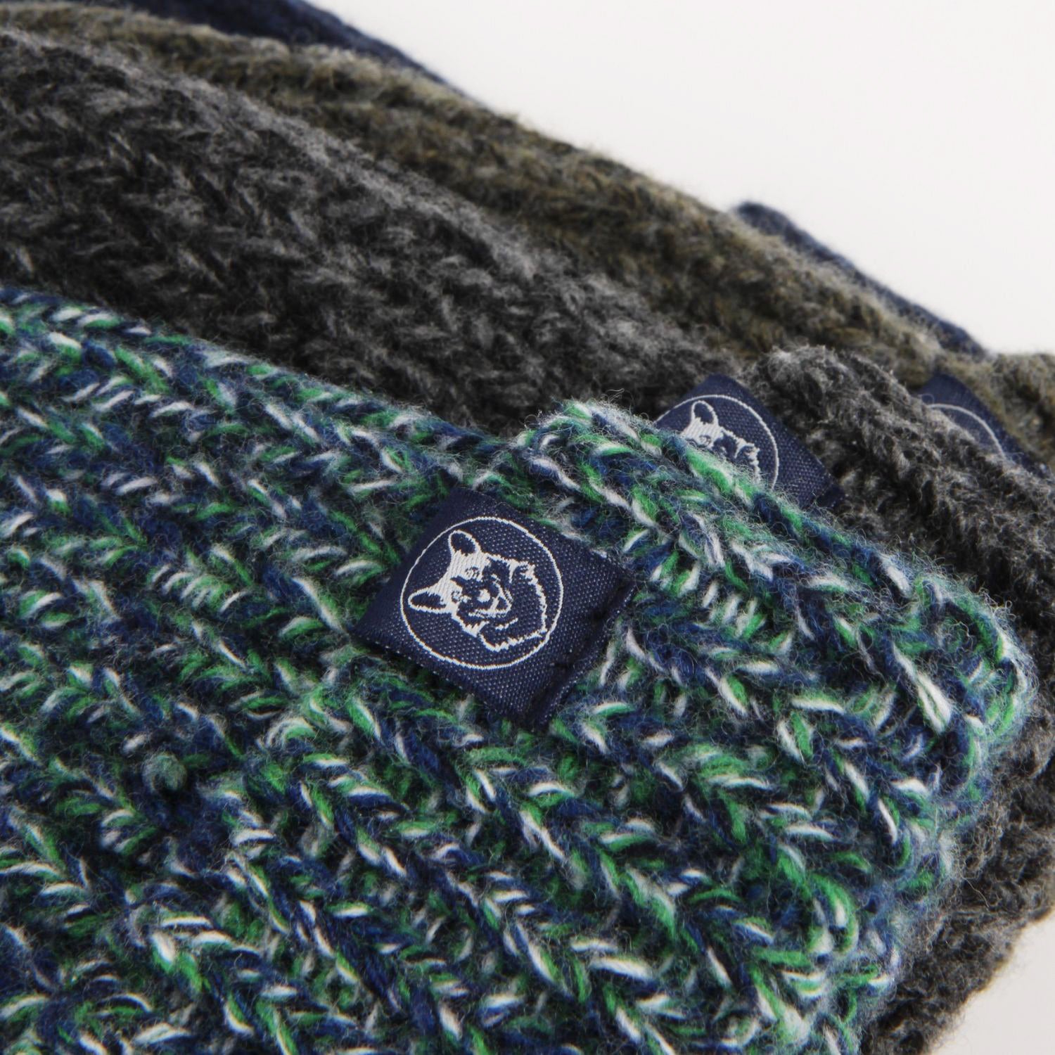 Close-up of a green and gray knitted product with a brand logo on a white background