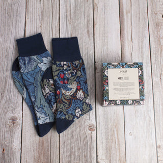 2 pairs of William Morris socks with a gift box on a wooden background