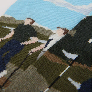 Socks with a pattern of people playing golf out in the sunshine.