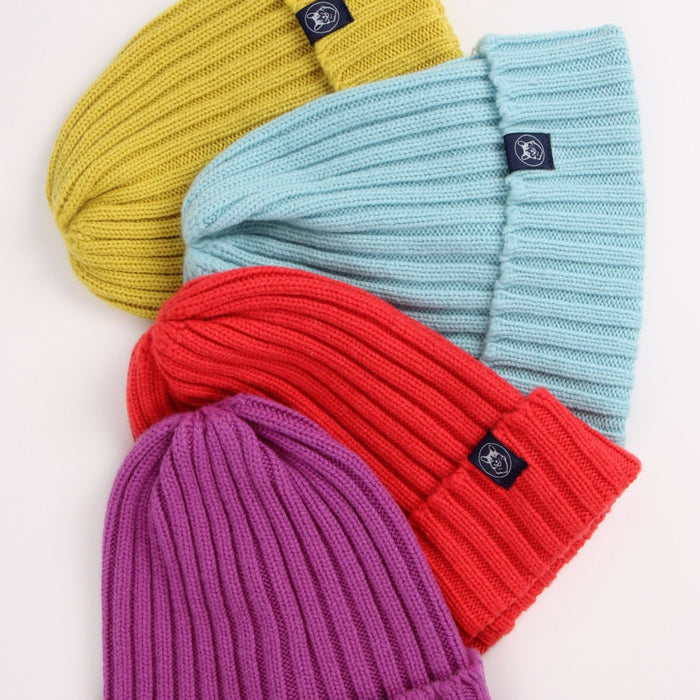 Four colorful beanies (yellow, light blue, red, purple) with brand logos on a white background.