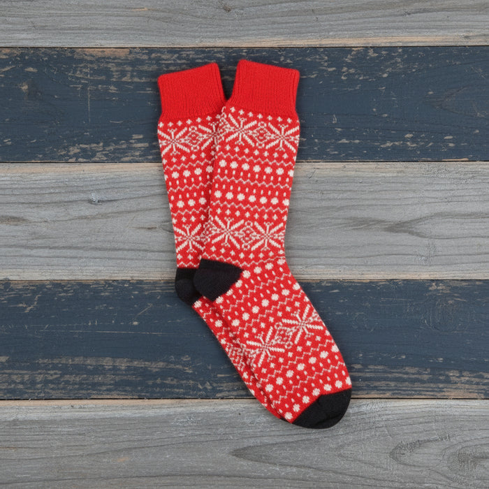 Red sock with white snowflake pattern on a white background