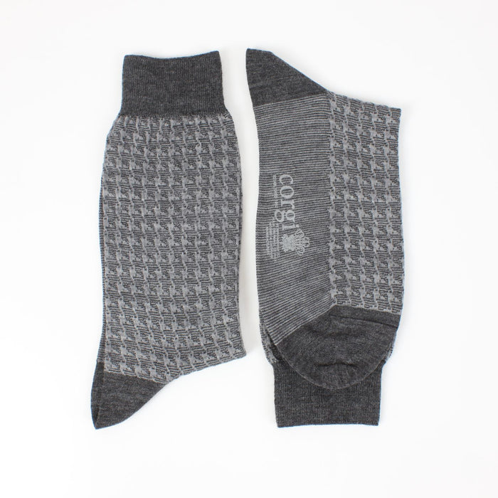 A pair of men's formal houndstooth merino wool socks in grey, showing the pattern and texture.