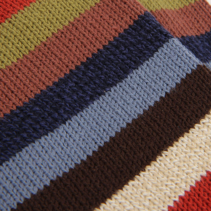 Close-up of a multicolored striped fabric with red, green, brown, blue, and beige stripes.
