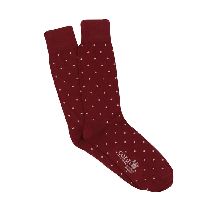 Maroon socks with white polka dots on a white background