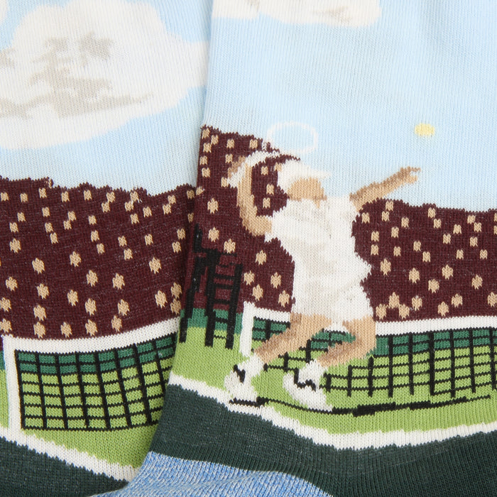 A pair of men's tennis socks with a pattern depicting a tennis player and crowd scene on a light background, with dark green at the cuffs.