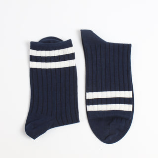 Navy blue socks with two white stripes on  the top end of the sock photographed on a white background