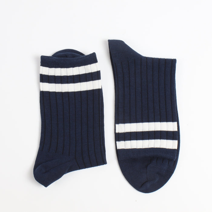 Navy blue socks with two white stripes on the top end of the sock photographed on a white background