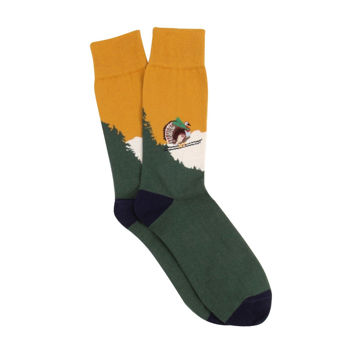 Green and mustard yellow sock with a turkey on a pair of skis, socks photographed on a white background