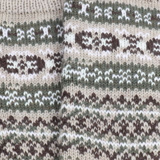Close-up of a knitted fabric with a pattern featuring brown, green, and white colors.