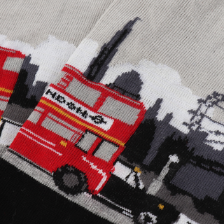 Close up image of a pair of women's socks with a London theme, featuring a red double decker bus on a black and silver background.