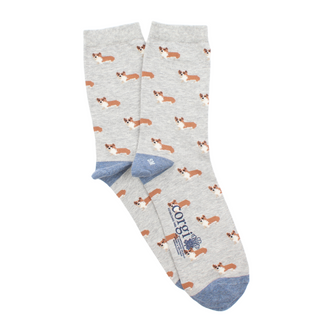 A pair of women's ankle socks with a corgi dog pattern in shades of grey, blue, and pink, worn with blue jeans.