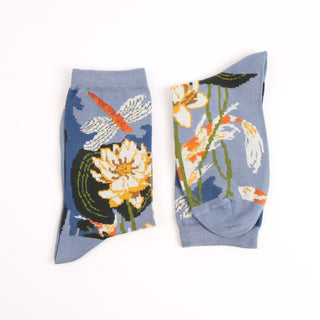 Pair of socks with floral and dragonfly design on a light blue background