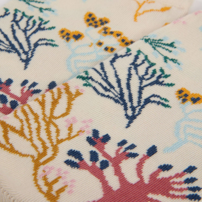 Close-up of a fabric with colorful coral reef pattern on a beige background