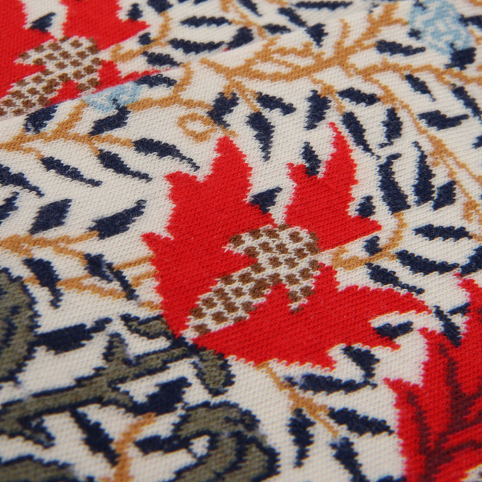 Close-up of a fabric with a floral pattern featuring red, blue, and beige colors.