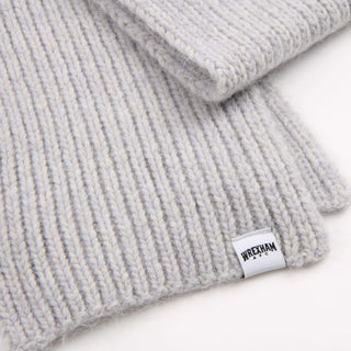 Grey knit beanie with a brand label on a white background