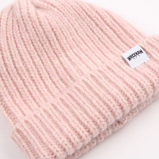 Pink knit beanie with a brand label on a white background