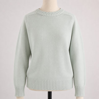 Light green sweater on a mannequin against a light pink background
