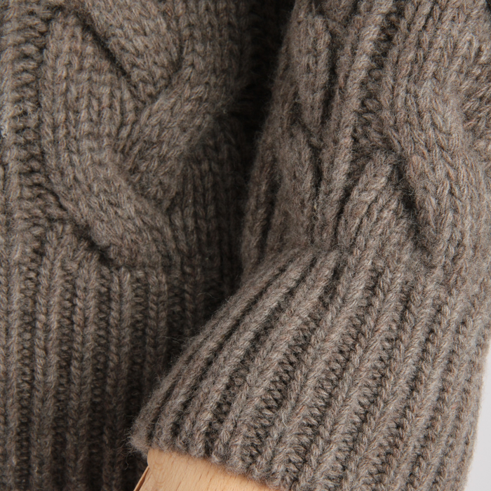 Close-up of a brown knitted sweater with cable pattern