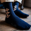A pair of navy blue cashmere socks with a monogram pattern, showing the socks' texture and the brand name 'Corgi'.