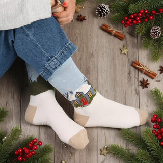 Sock with a winter scene of a house and trees on a light blue background