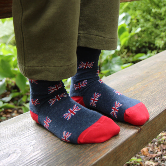 Child wearing socks with Union Jack design on a wooden bench outdoors