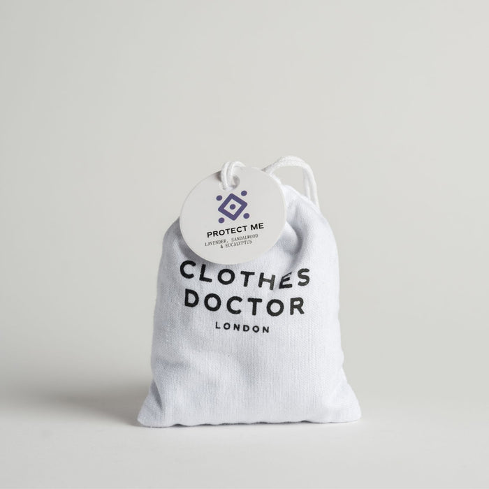 A white cotton sachet labeled 'Protect Me - Clothes Doctor London' containing natural scent bags for wardrobe use.