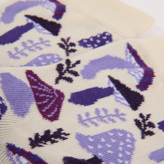 Close-up of a knitted fabric with purple and black geometric patterns on a beige background