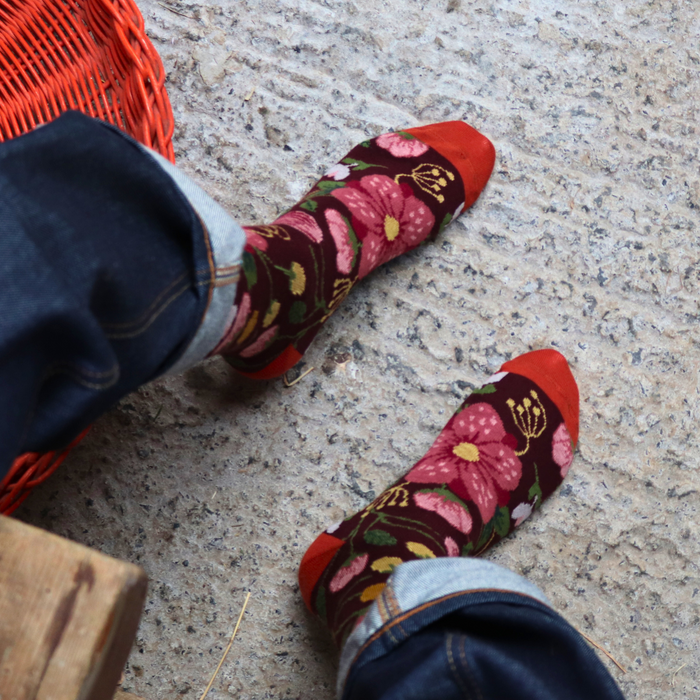 Person wearing floral patterned socks on a concrete floor