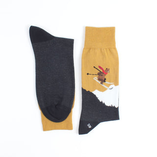 A pair of men's socks with a Christmas-themed design featuring a skiing bear