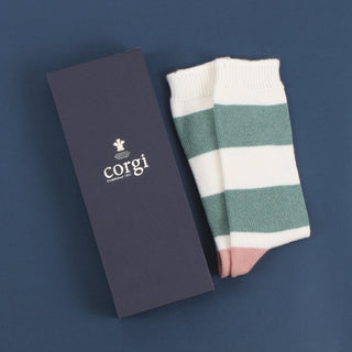 A pair of women's cashmere and cotton colour block socks with stripes in green and pink shades, and a gold toe with gift box.