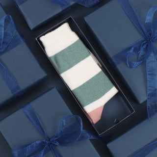 A pair of women's cashmere and cotton colour block socks with stripes in green and pink shades, and a gold toe.