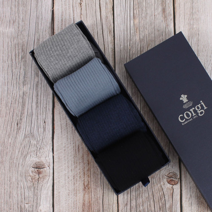 A set of men's cotton socks displayed next to their packaging box, with colors including navy, silver, and blue.