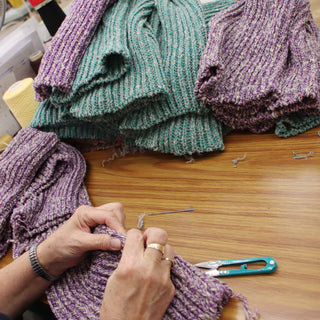 person at the factory hand finishing the cashmere blend beanies