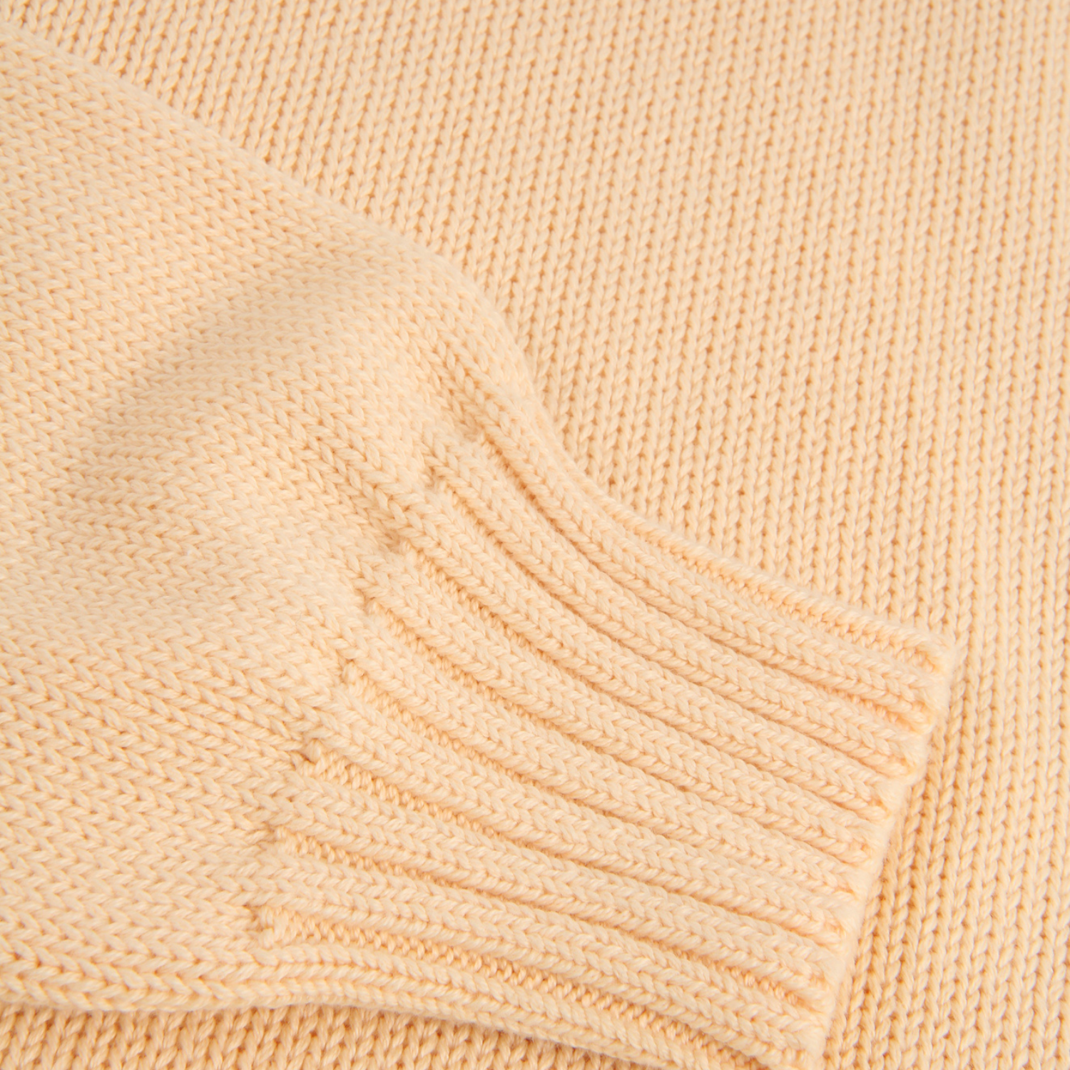 Close-up of a yellow knitted fabric with a ribbed texture.