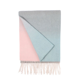 A woven cashmere scarf in ombre colour with a geometric triangle shape on a white background, featuring a fringe at the bottom.