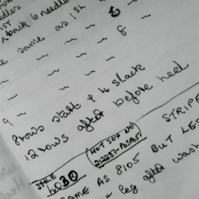 Handwritten knitting instructions on a piece of paper with text and numbers.