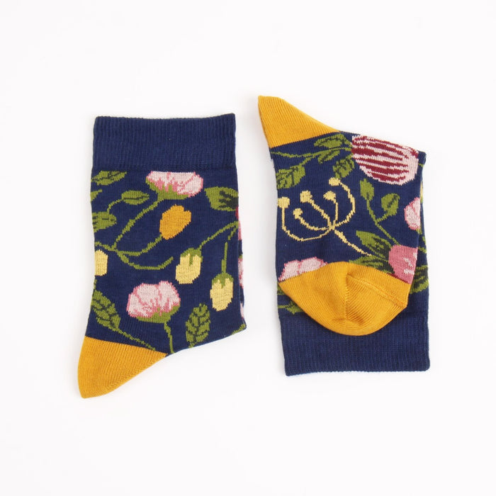 Pair of socks with floral pattern and yellow accents on a white background