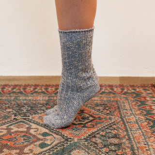 woman wearing blue melange cotton socks on a cosy rug