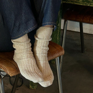 woman wearing cosy wool socks sitting on a chair