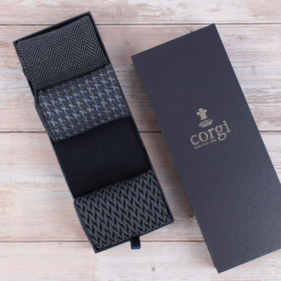A box of Corgi brand men's dress socks, containing four pairs with different patterns, displayed next to its packaging.