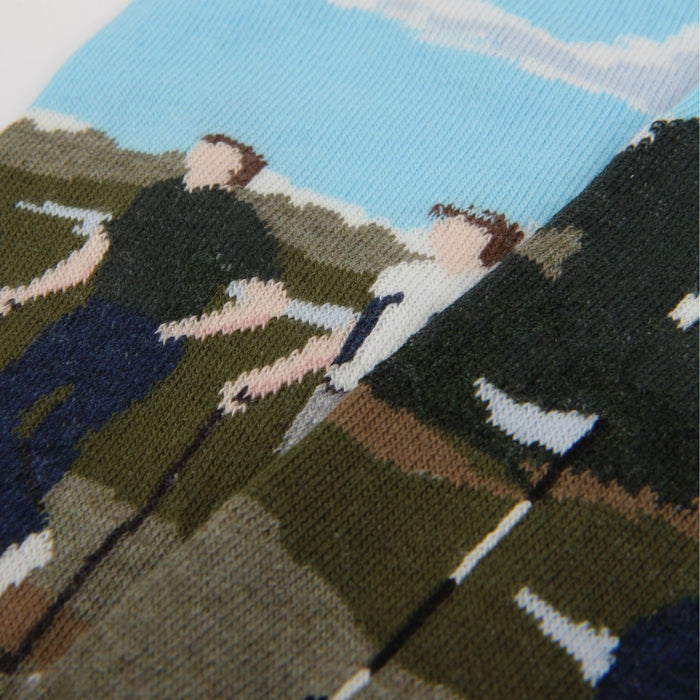 Socks with a pattern of people playing golf out in the sunshine.