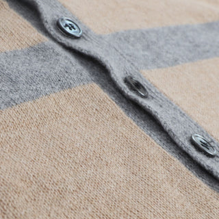 Close-up of a striped fabric with gray and beige pattern and button details.