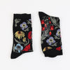 Pair of black socks with colorful floral patterns on a white background