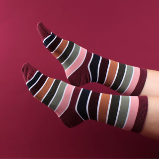 woman wearing striped cotton socks on a red background