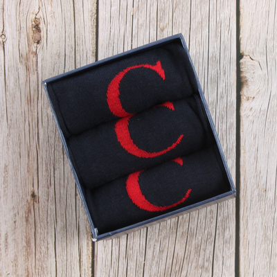 3 pairs of letter 'C' socks in a gift box on a wooden background
