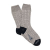 A pair of hand-knitted gray cable cashmere and cotton socks with the brand 'Corgi' visible.